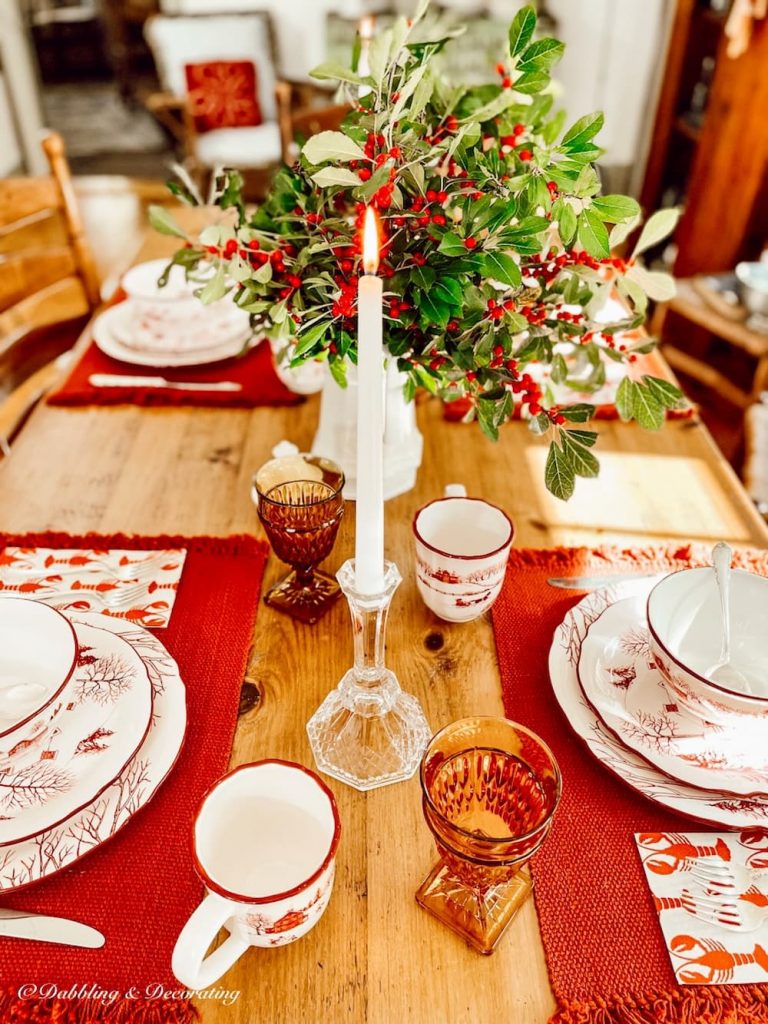 Winterberry centerpiece on red toile Christmas styled tablescape.