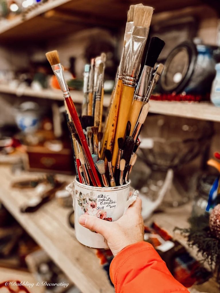 Vintage Paintbrushes in ceramic jar in hand.