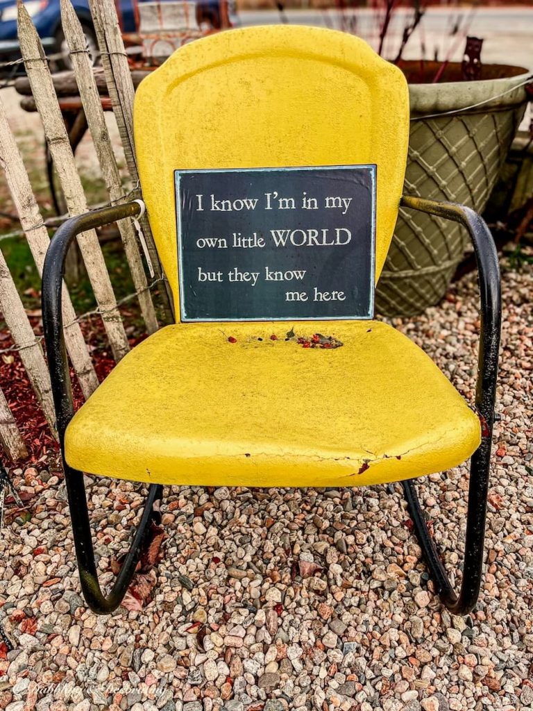 Antique yellow chair with sign.
