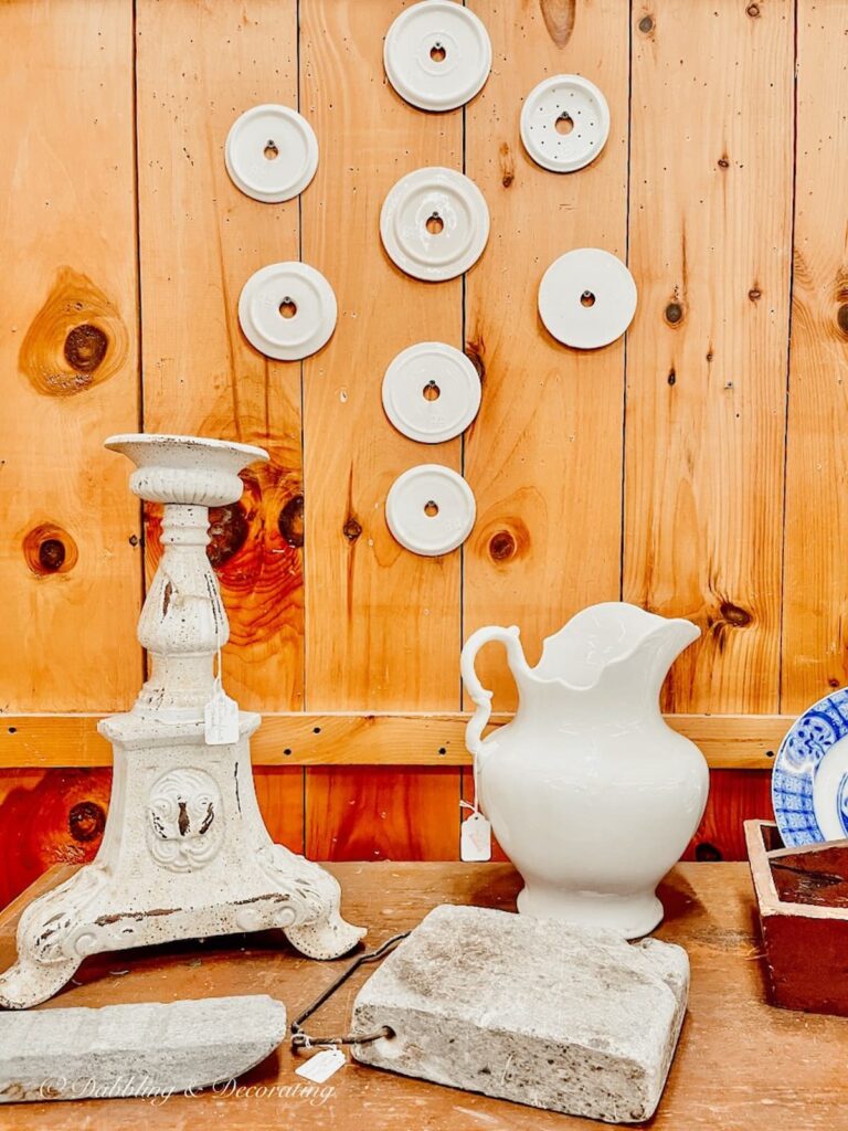 Vintage soap dish inserts hanging on a wall at a vintage marketplace.