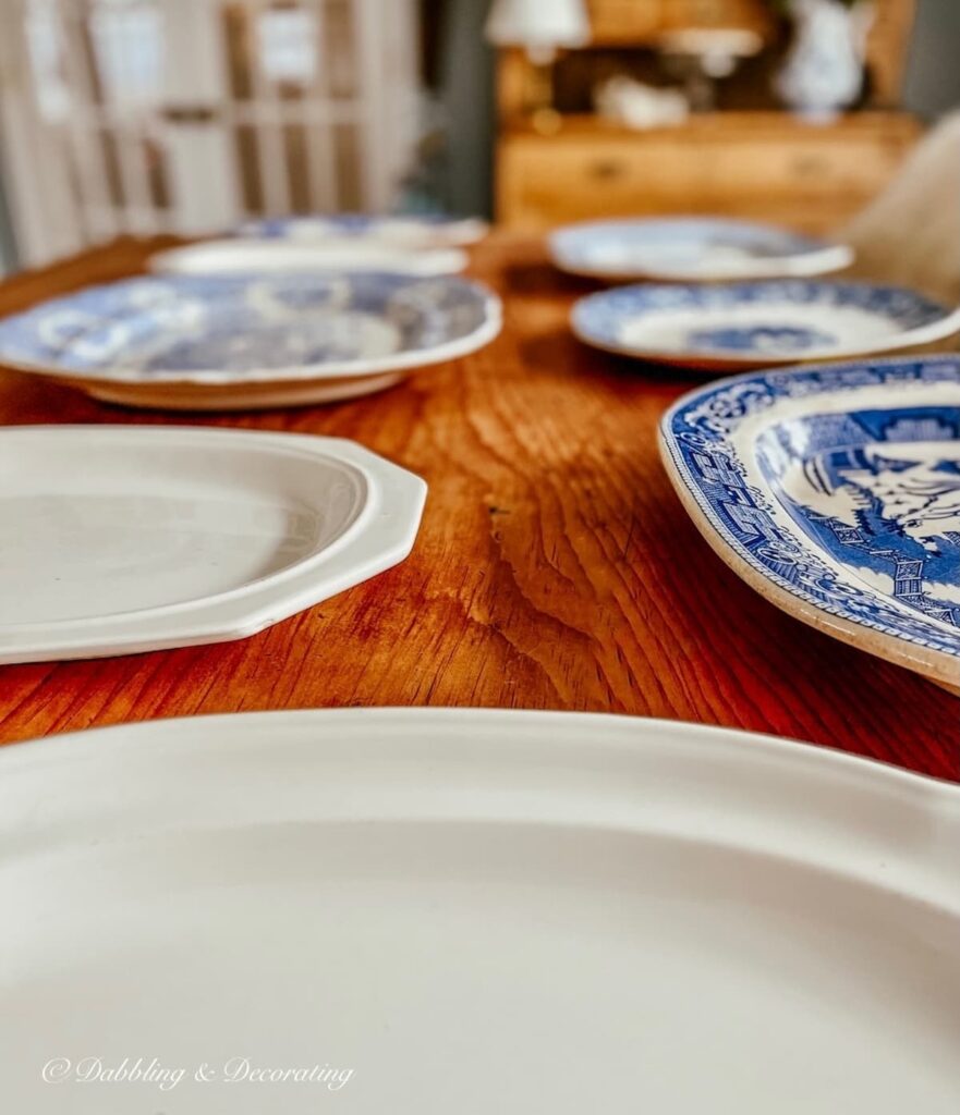 Vintage blue and white platter collection laid out on table.