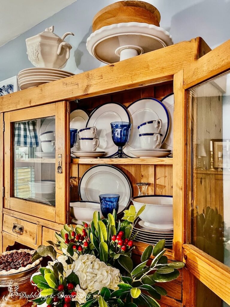 Antique china cabinet with blue and white china and glassware.