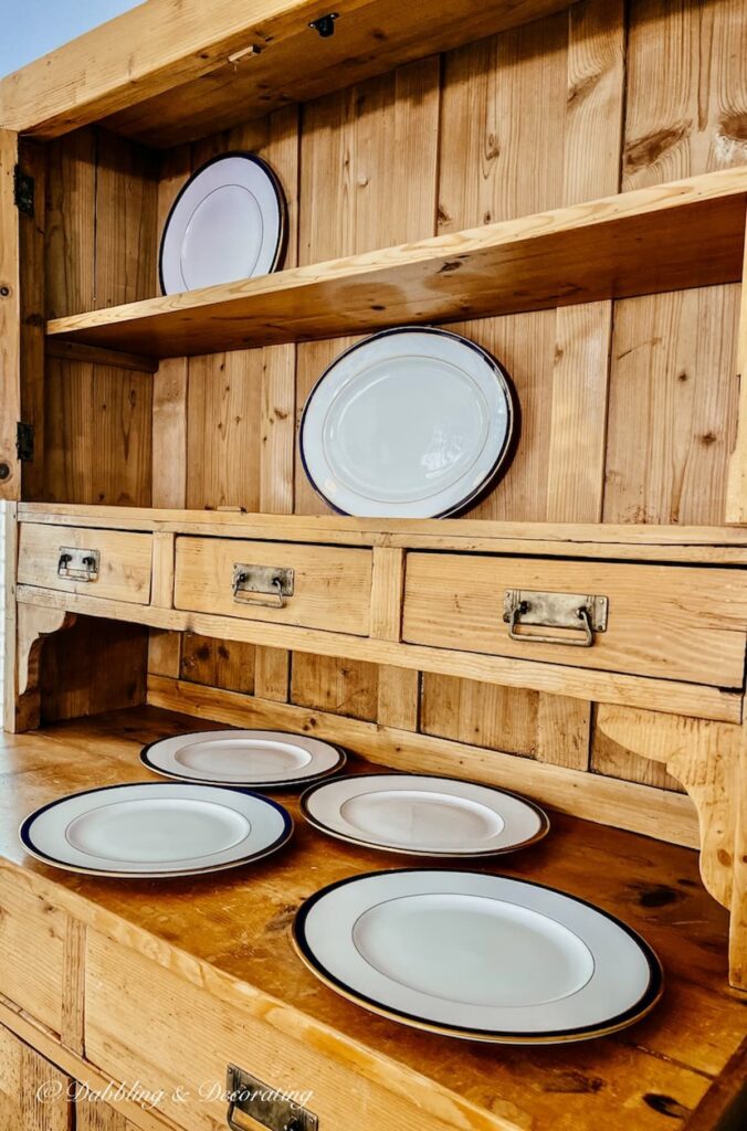 Vintage China Hutch with scattered china plates on shelving.