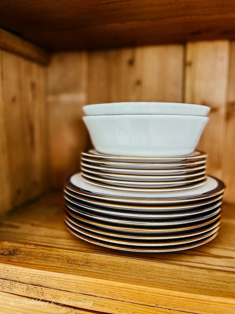 Stacked china plates in vintage china hutch.