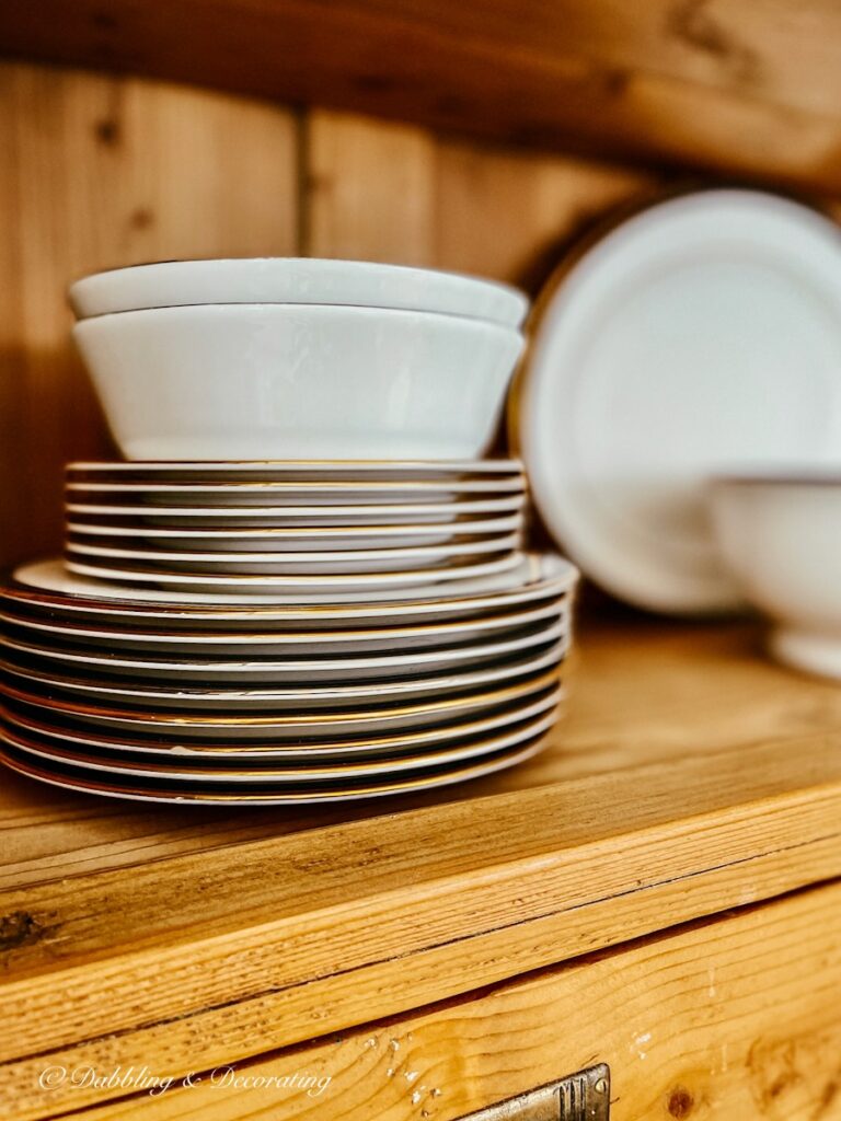 Stacked china plates in vintage china hutch.