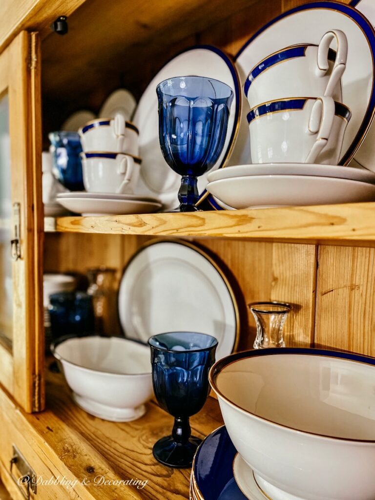 Blue glassware with blue and white china display in vintage china hutch.