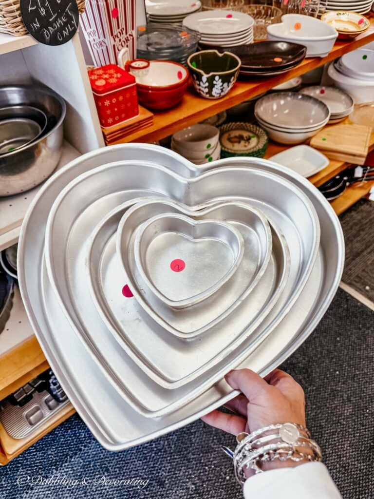 Collection of different sized heart cake tins in thrift store in hand. Vintage Valentine's Day Decor ideas.