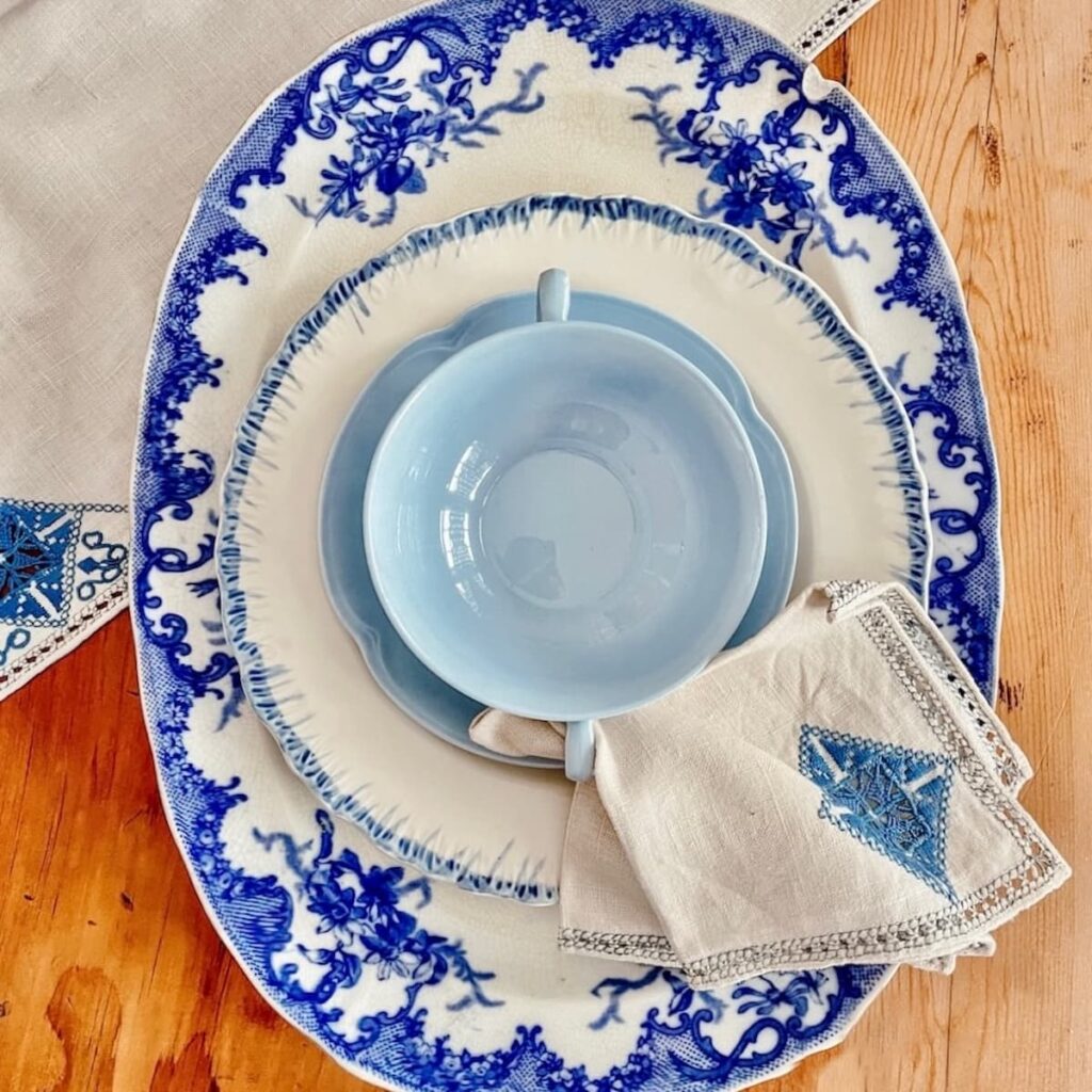 Blue and white platter and dishes place setting on table.