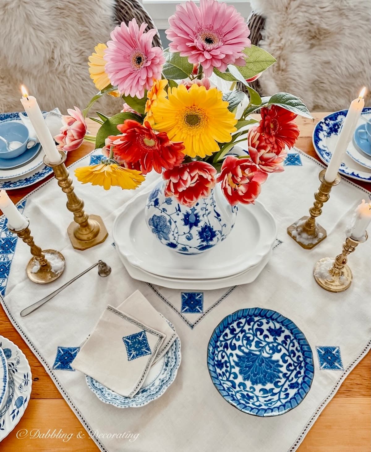Vintage table decorations with blue and white details a spring flower centerpiece.