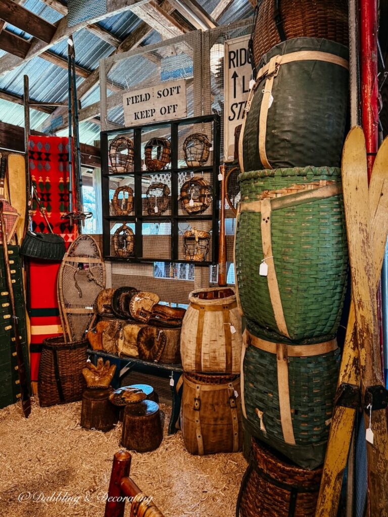 Winter vintage booth display with old basket backpacks stacked high at the Country Living Fair.