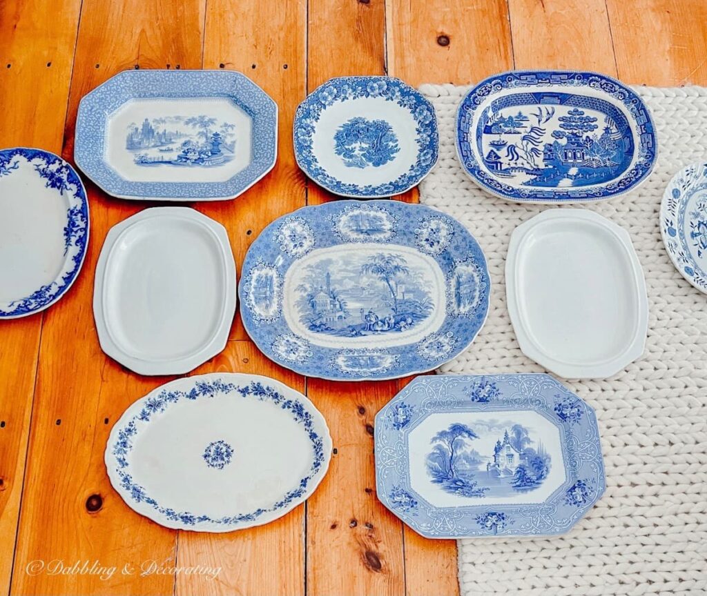 10 blue and white vintage platters laid out on floor creating the design for a Vintage Plate Wall.