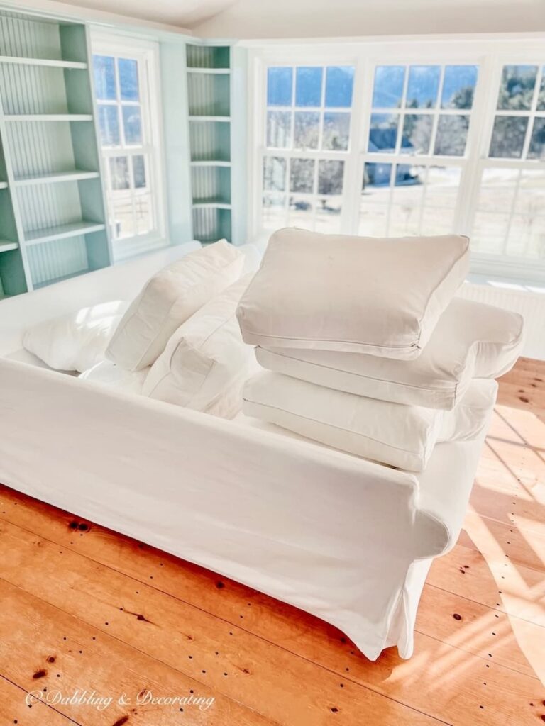 Benjamin Moore Sunroom Paint Colors That Work, Our Wedgewood Gray Makeover with Chantilly Lace, white sectional and wood flooring.