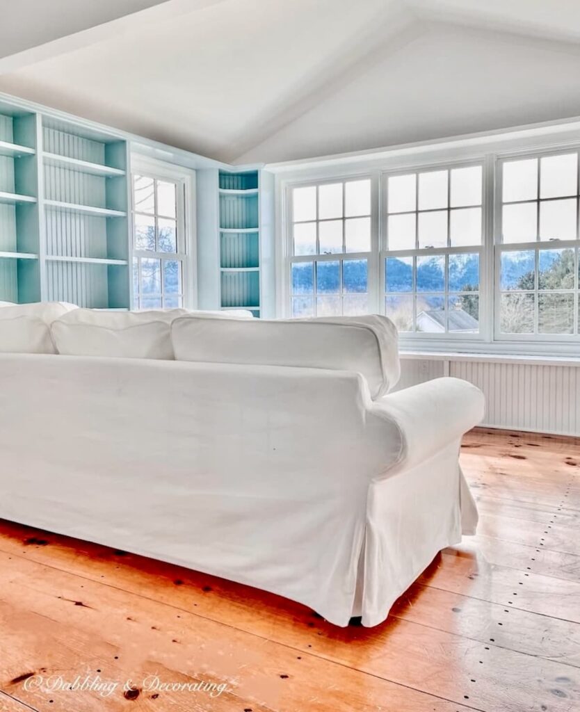 Benjamin Moore Sunroom Paint Colors That Work, Our Wedgewood Gray Makeover with Chantilly Lace and white sectional with wood floors and mountain views.