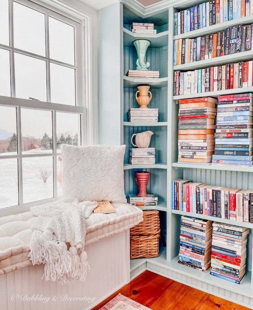 Built-in Bookcases with vintage eclectic vases and books and window view.