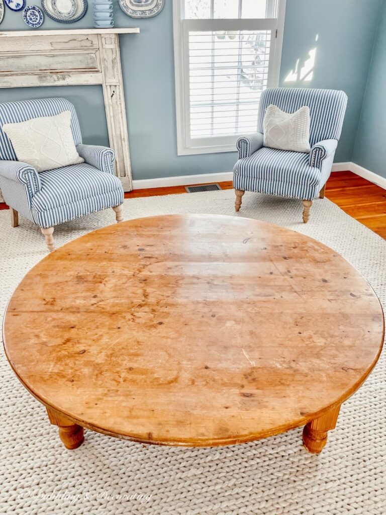 Breakfast nook round pine table with two chairs in corner nook.