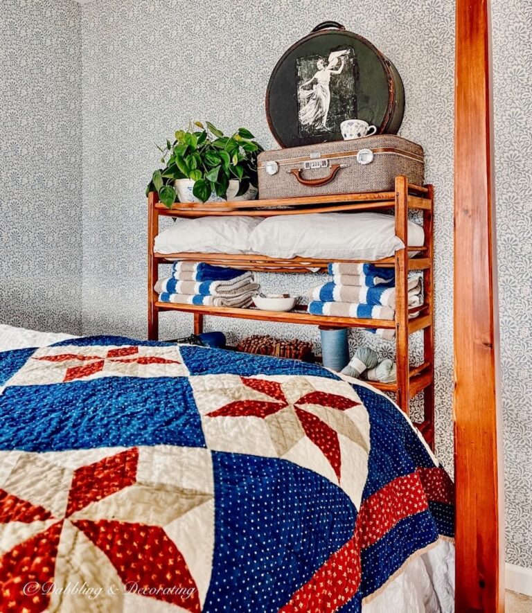 Vintage cobbler shoe stand styled in guest bedroom with four poster bed and antique quilt.