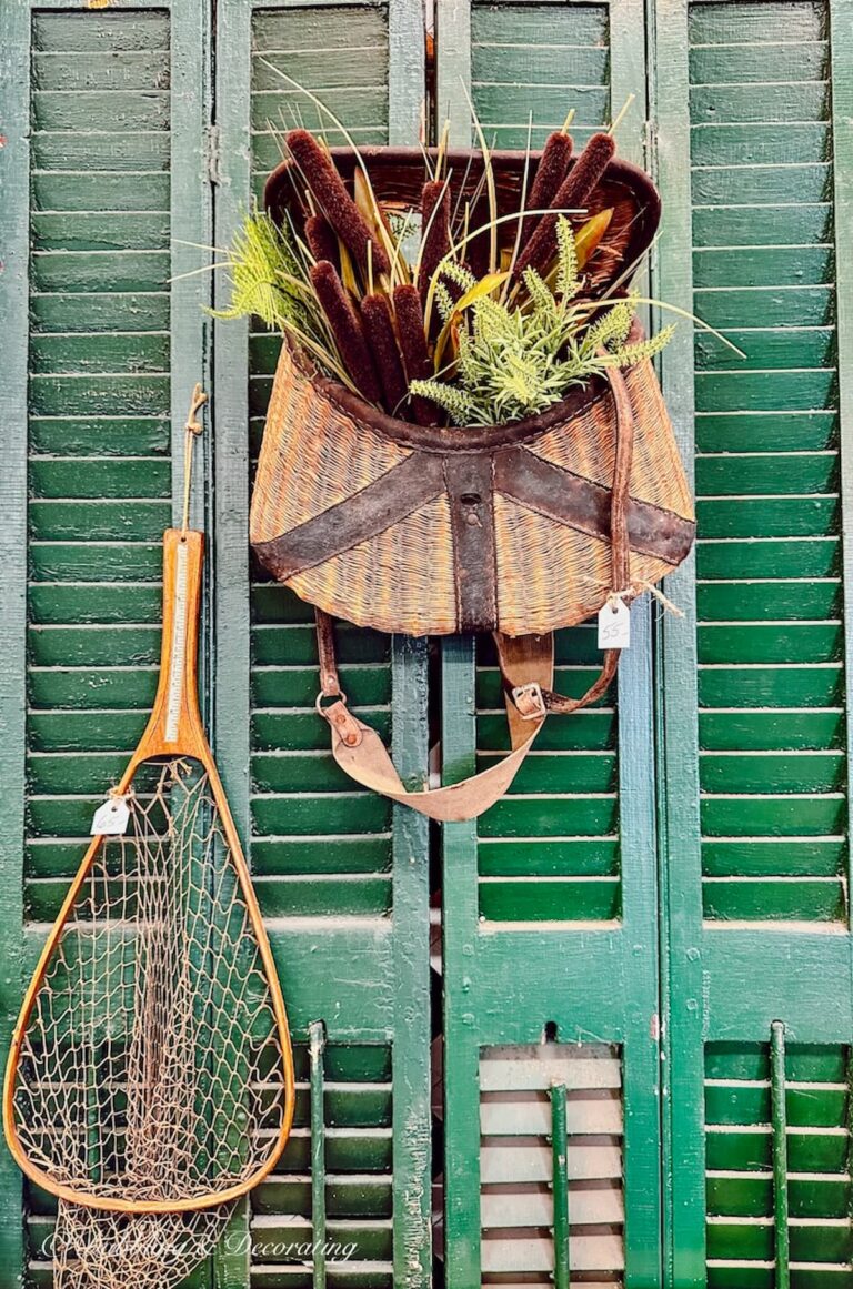 Vintage Fishing Basket Bouquet with fishing net on green shutters at flea market.