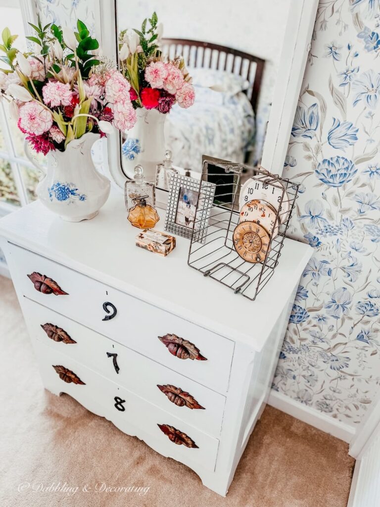 Painted white DIY dresser with eclectic home decor accessories.