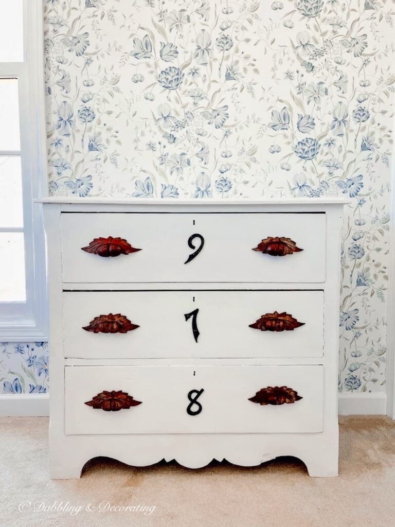 painted white dresser refashioned with wrought iron house numbers.