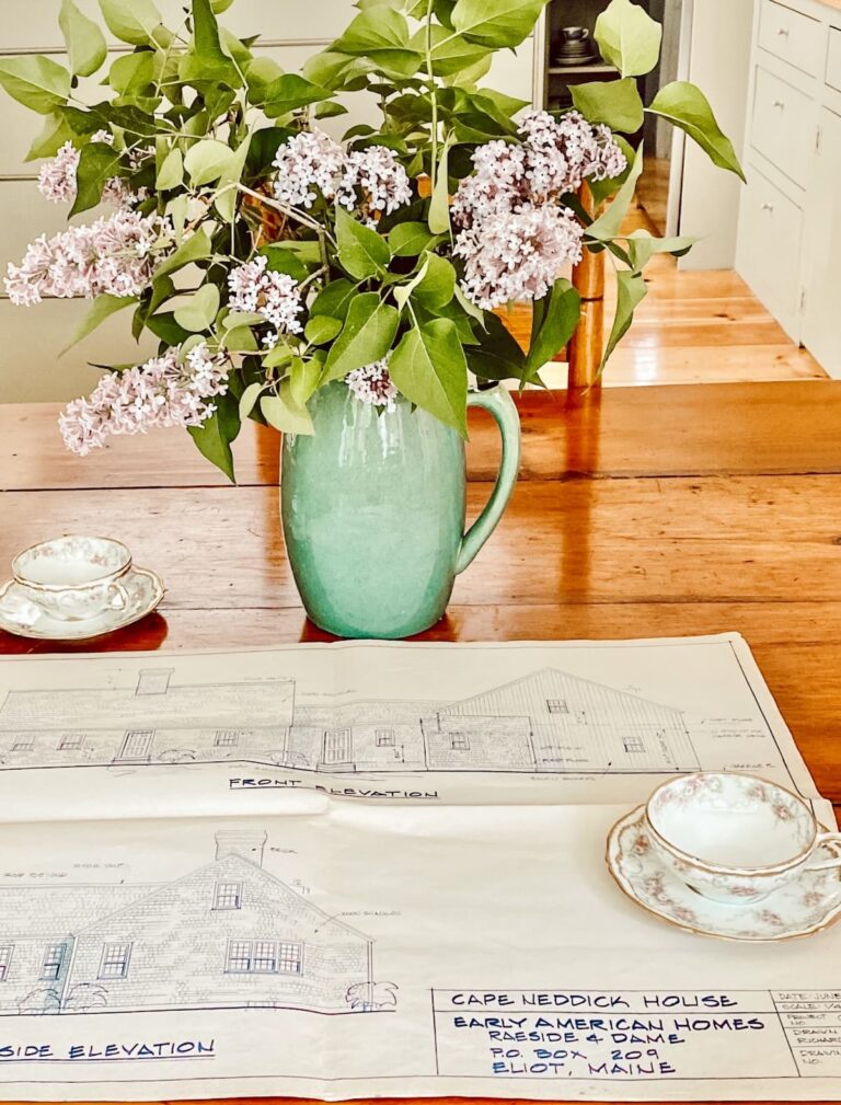 Colonial House Drawings with Lilac Bouquet on Dining Room Table.