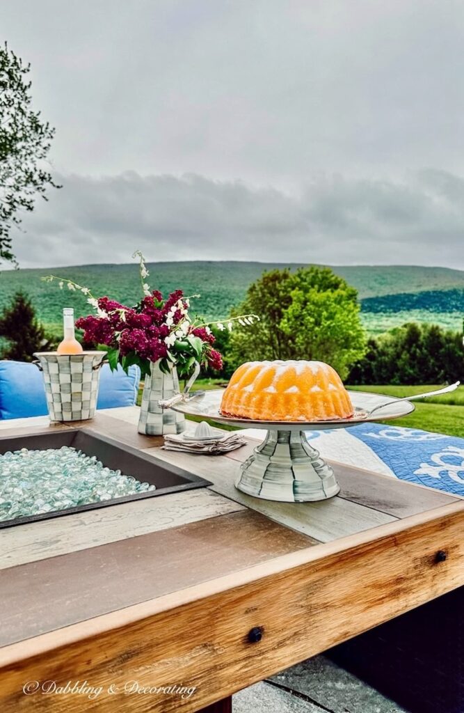 Cake on Cake stand, lilac bouquet, outdoor fire pit.