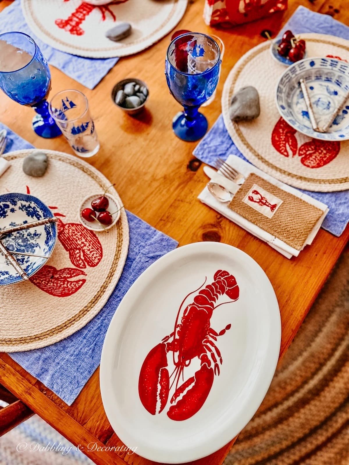 Summer table decorations in Patriotic style with red, white, and blue lobster place settings from an authentic Coastal Maine dining room.