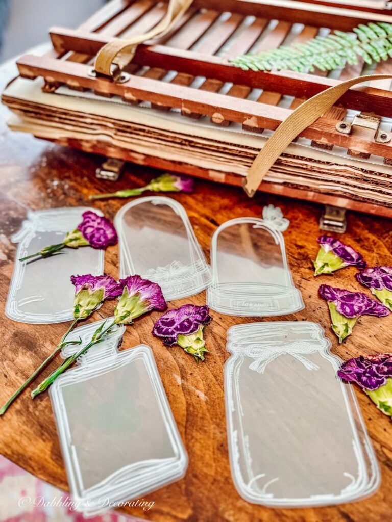 Bottle Bookmarks and pressed flowers next to a vintage flower press.