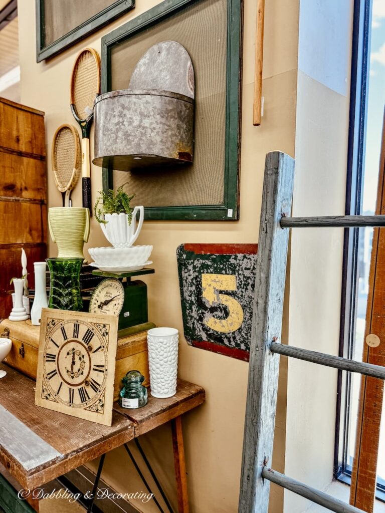 Vintage booth at vintage bazaar new england with vintage home items hanging on a wall.