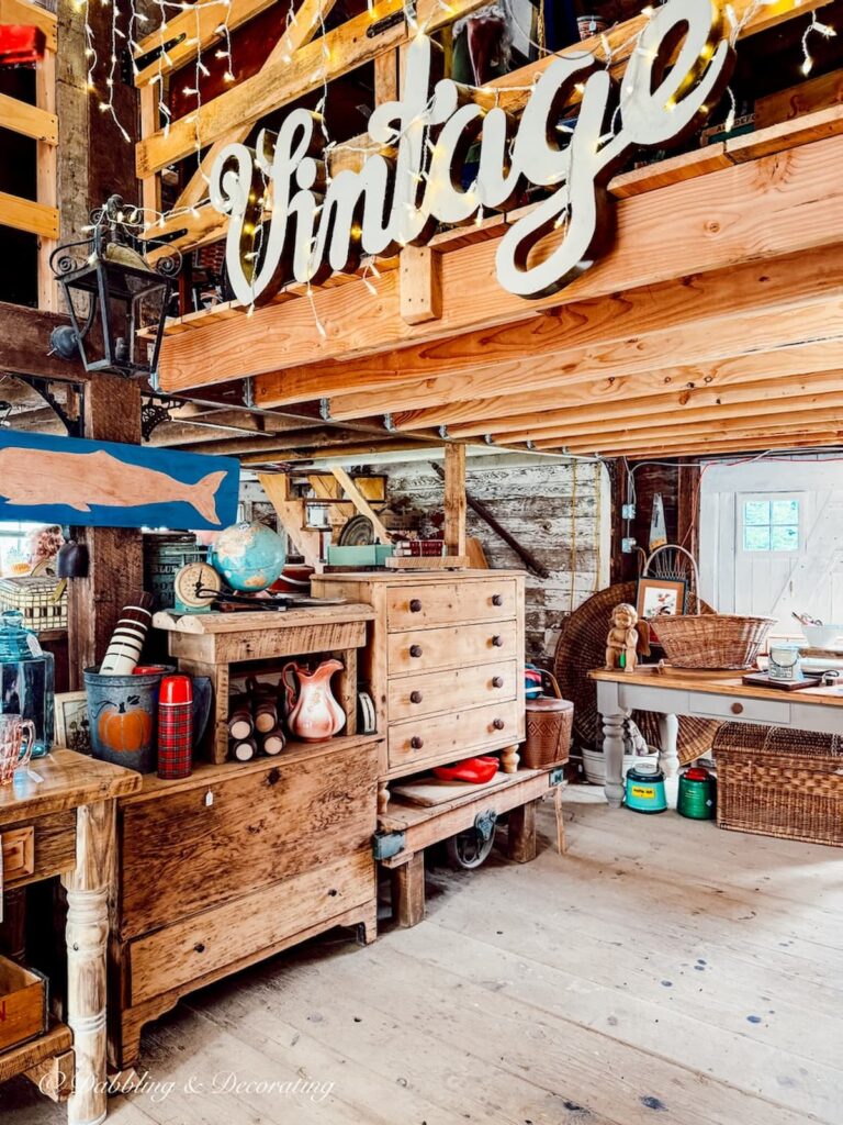 Inside a Barn Sale with the word Vintage in Lights hanging from rafters.