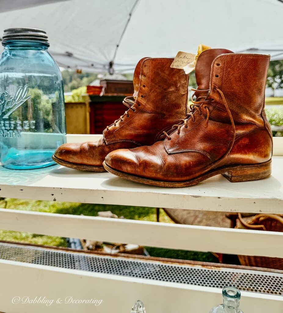 Vintage womens leather boots at barn sale on shelf.