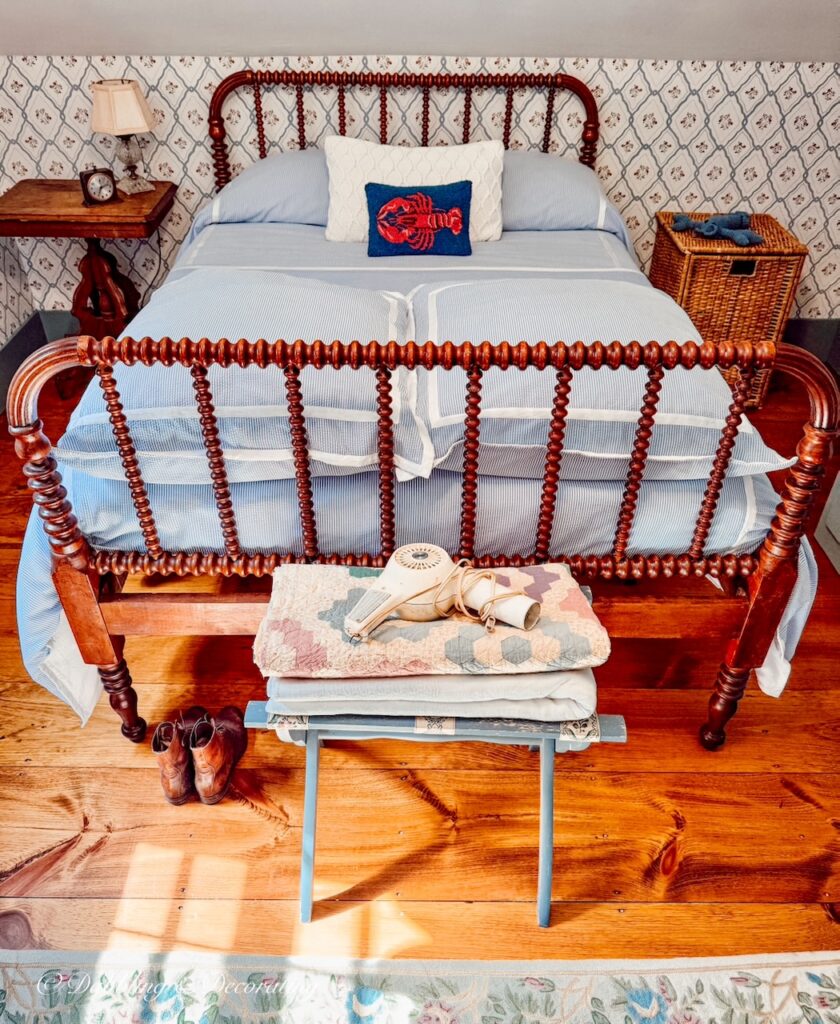 Antique styled bedroom with Jenny Lind bed and antique shoes at the foot of bed.