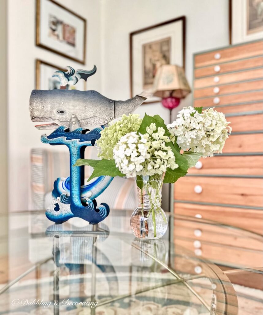 Balancing Whale Toy with White Hydrangeas on Glass Table