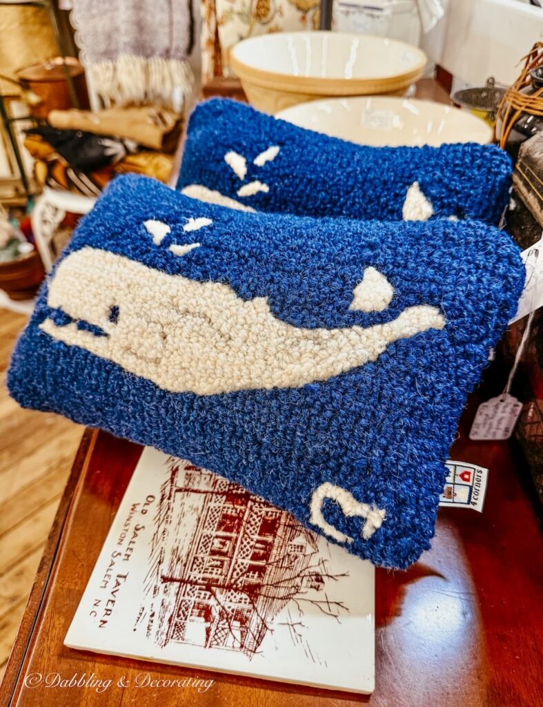 Two Chandler 4 Corners small whale pillows in an antique store in Maine.