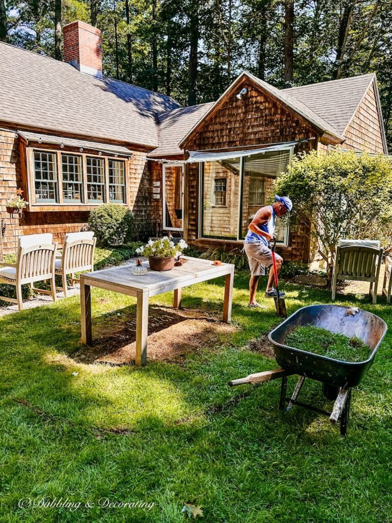 Man with shovel digging patio