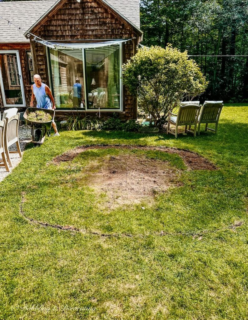 Man with Wheelbarrow building pea gravel patio.