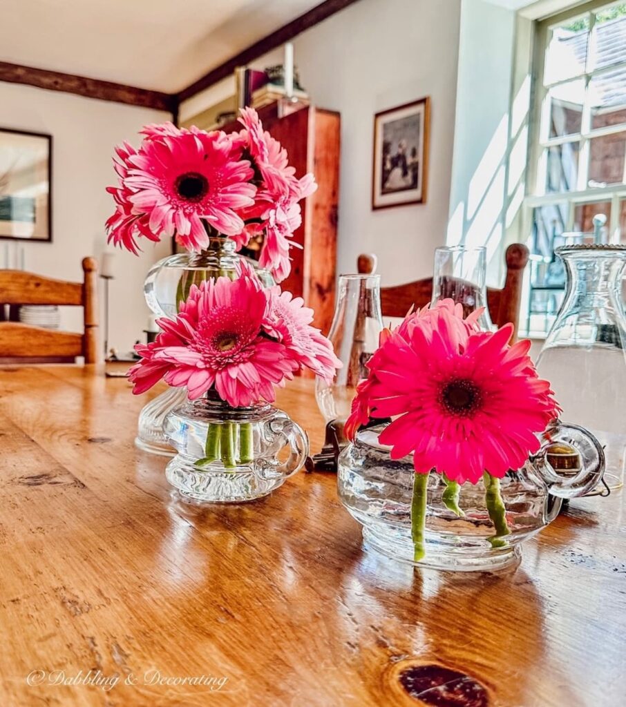 Oil Lamps into A Unique Flowers Vase with pink flowers on table.