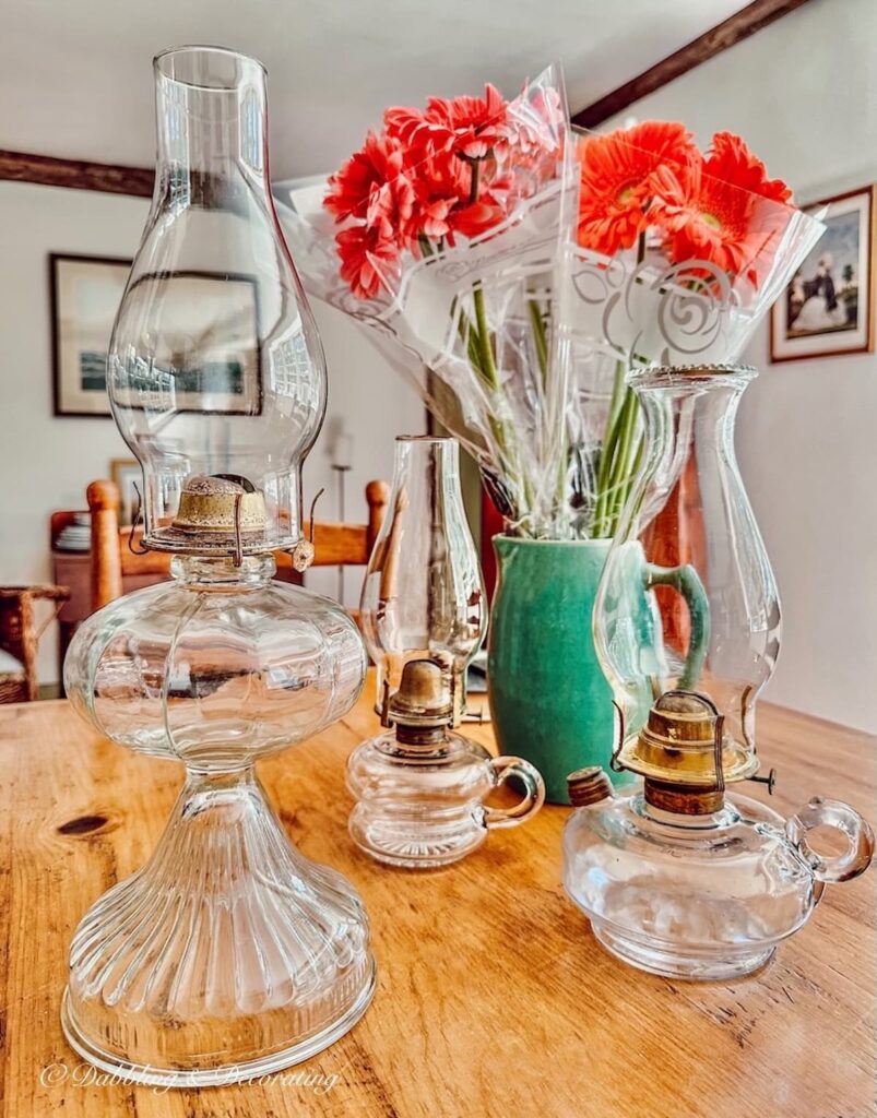 3 Oil Lamps and Vase of Flowers