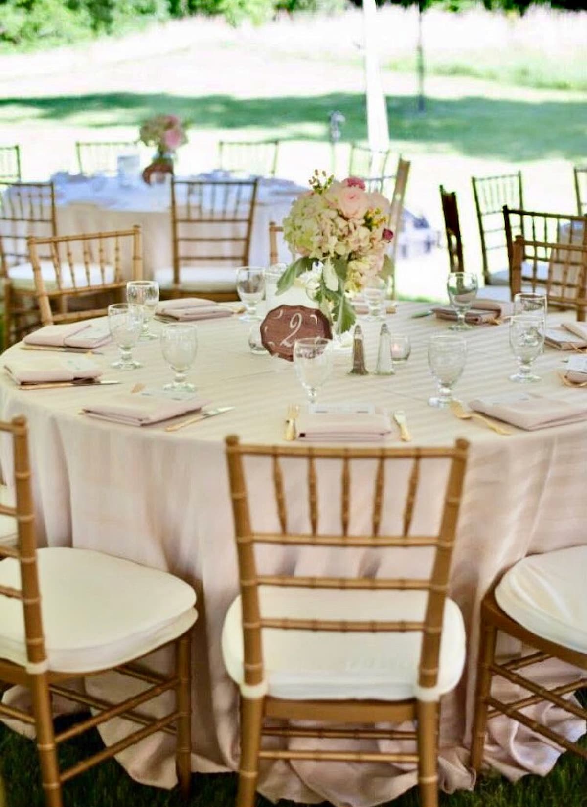 Wedding Antique Oil Lamps on tables with pastel flowers as centerpieces.