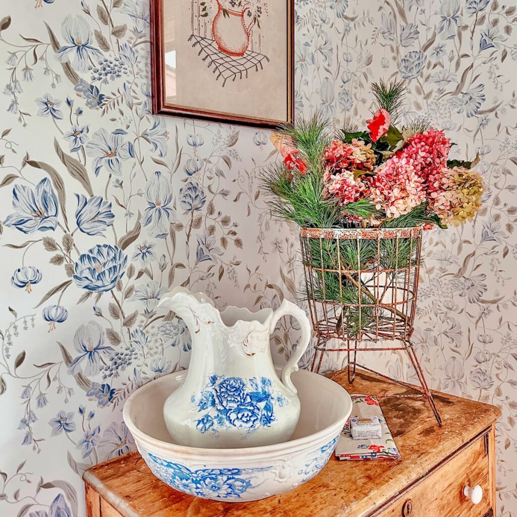 Decorating with fall hydrangeas in pink with wired basket on antique dresser with water basin and pitcher in bedroom.