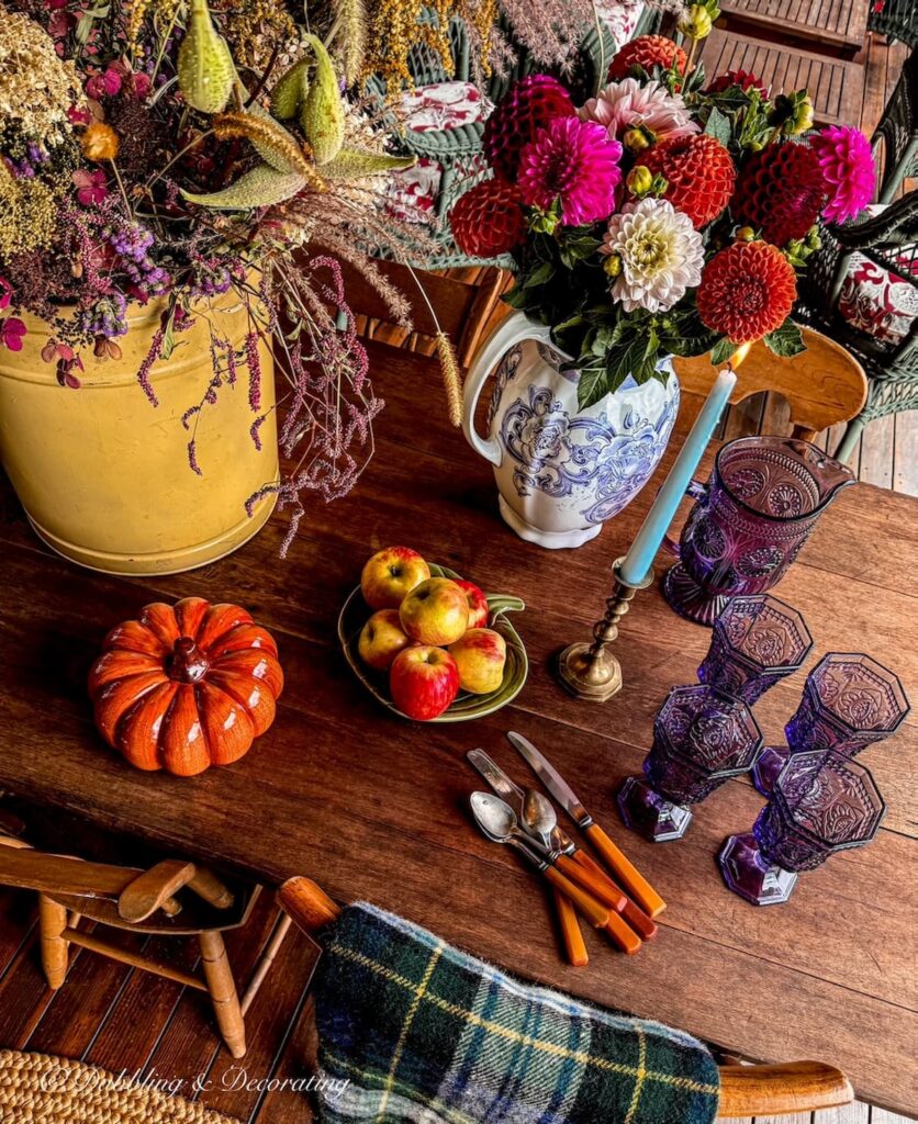 Outdoor vintage porch table with Autumn flower arrangements in vintage tin and pitcher.