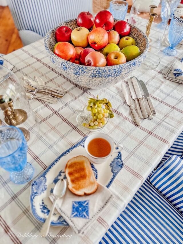 Blue and table setting paired with Johnson Brothers Tea and Toast plates on table with centerpiece filled with apples.