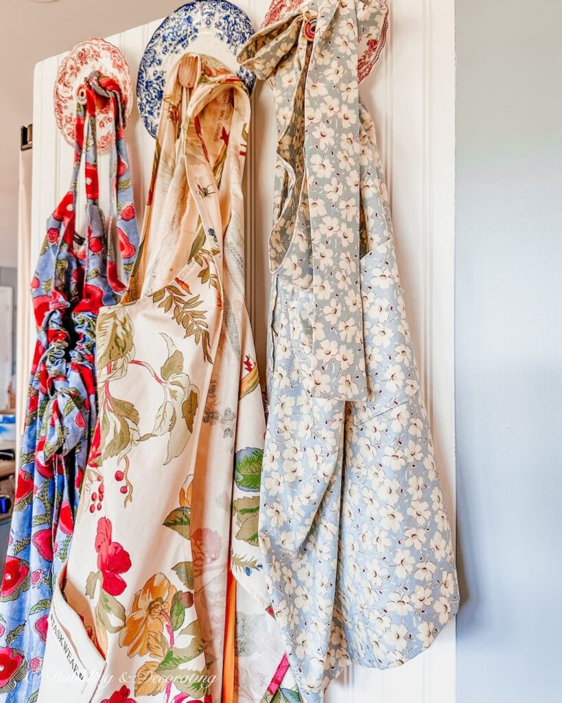 Red and White Plate wood wall Hooks with aprons in kitchen.