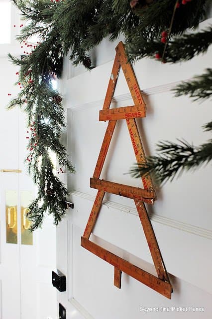 A Christmas tree hanging on a door, adorned with 12 Days of Christmas decorations.