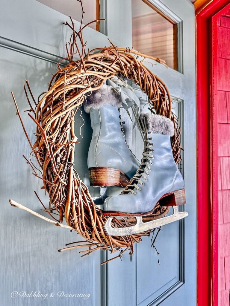 A festive wreath adorned with a pair of ice skates, perfect for your 12 Days of Christmas decorations.