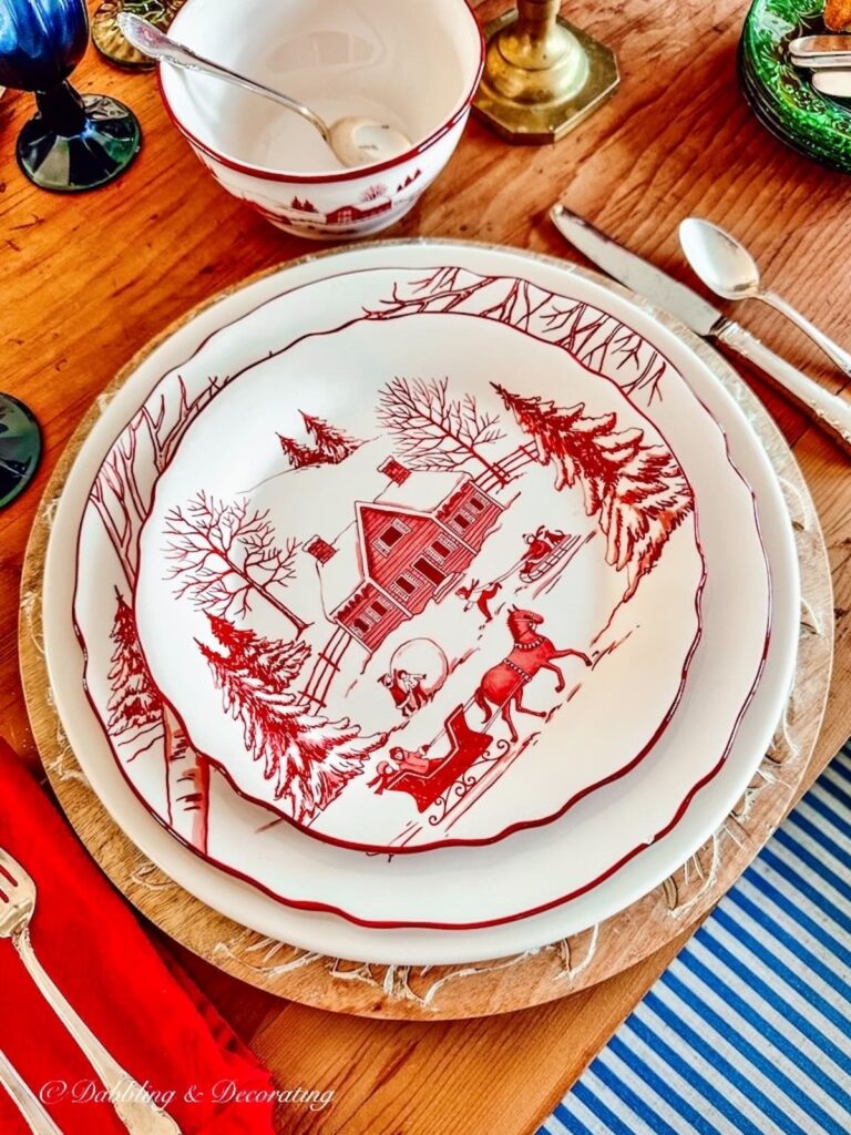 A cabin decor table setting with red and white plates and silverware.
