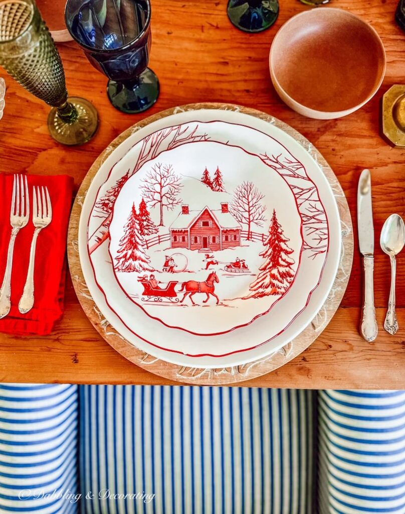A cabin-themed table setting with red and white plates and silverware.