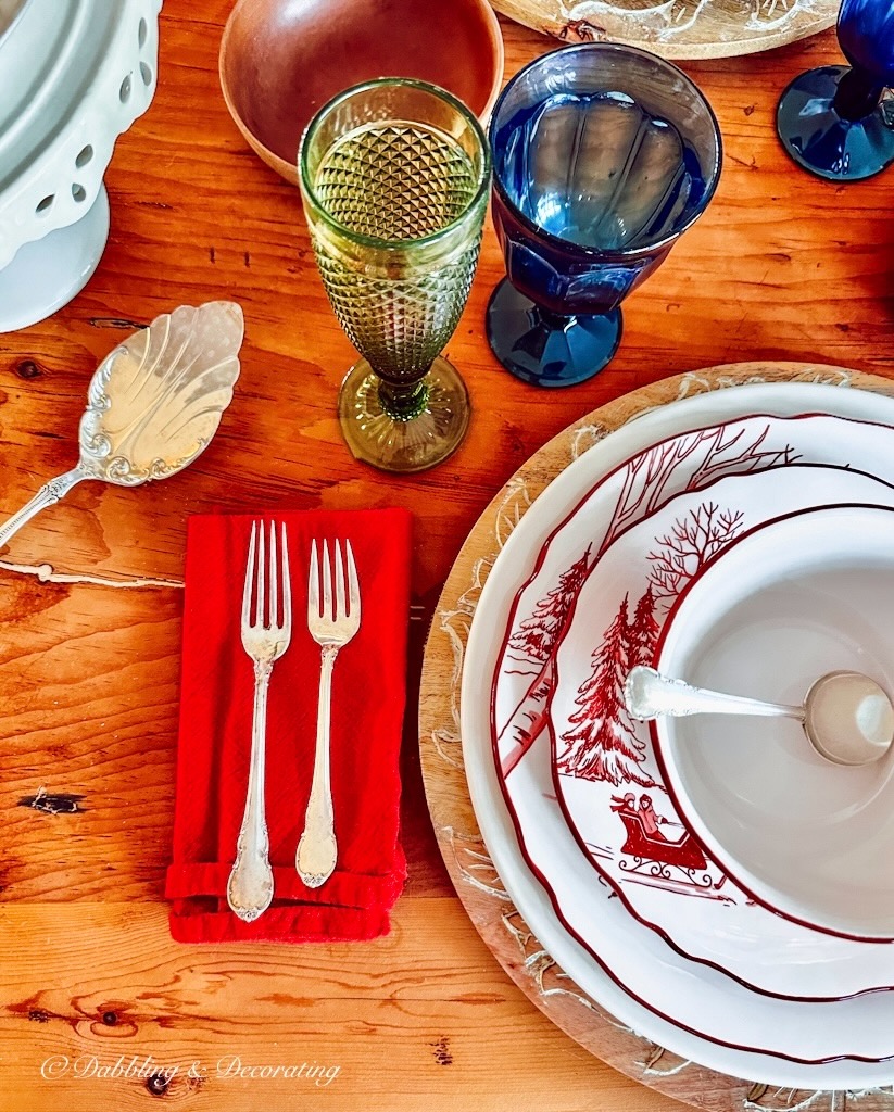 A rustic table setting with plates and silverware on a wooden table in a cozy cabin.