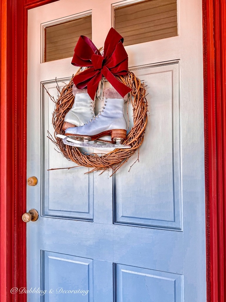 A festive wreath adorned with a pair of ice skates, perfect for 12 Days of Christmas decorations.