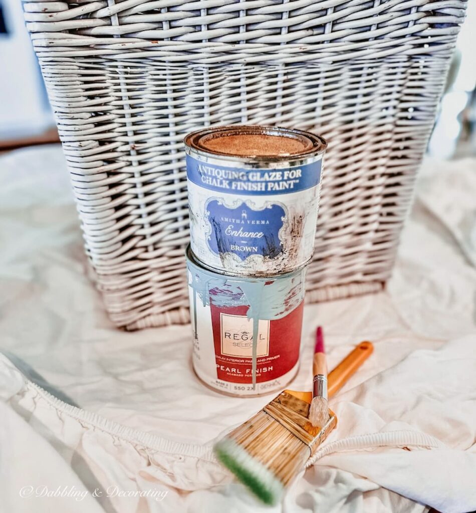 Paint and Stain cans with paint brushes and laundry Basket.