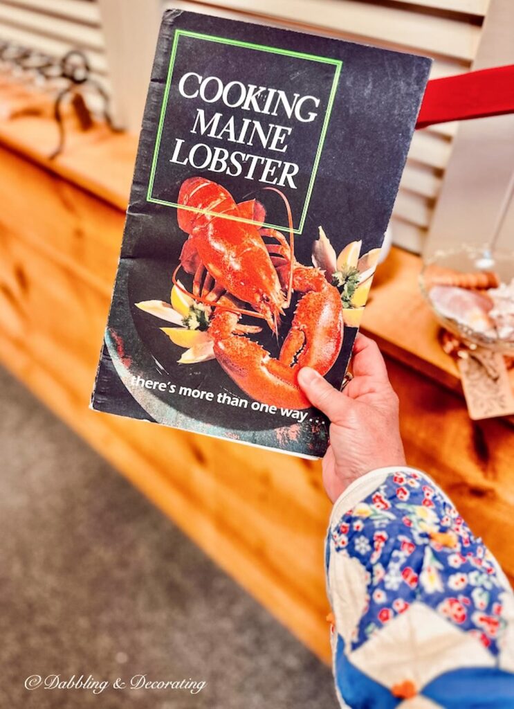 Cooking Maine Lobster Vintage cookbook in hand at antique store.